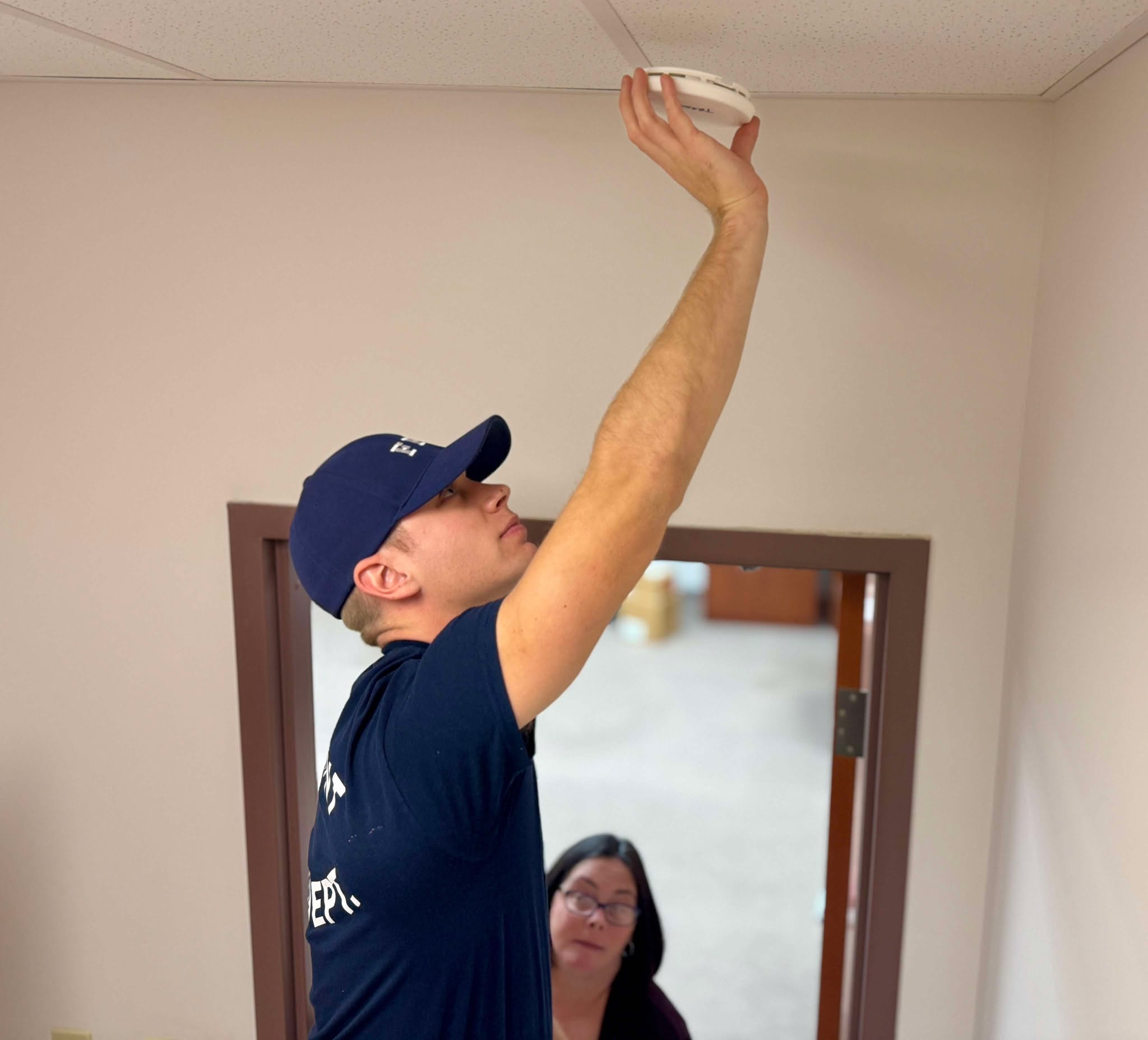 A member of the Fairmont Fire Department installs a smoke detector.