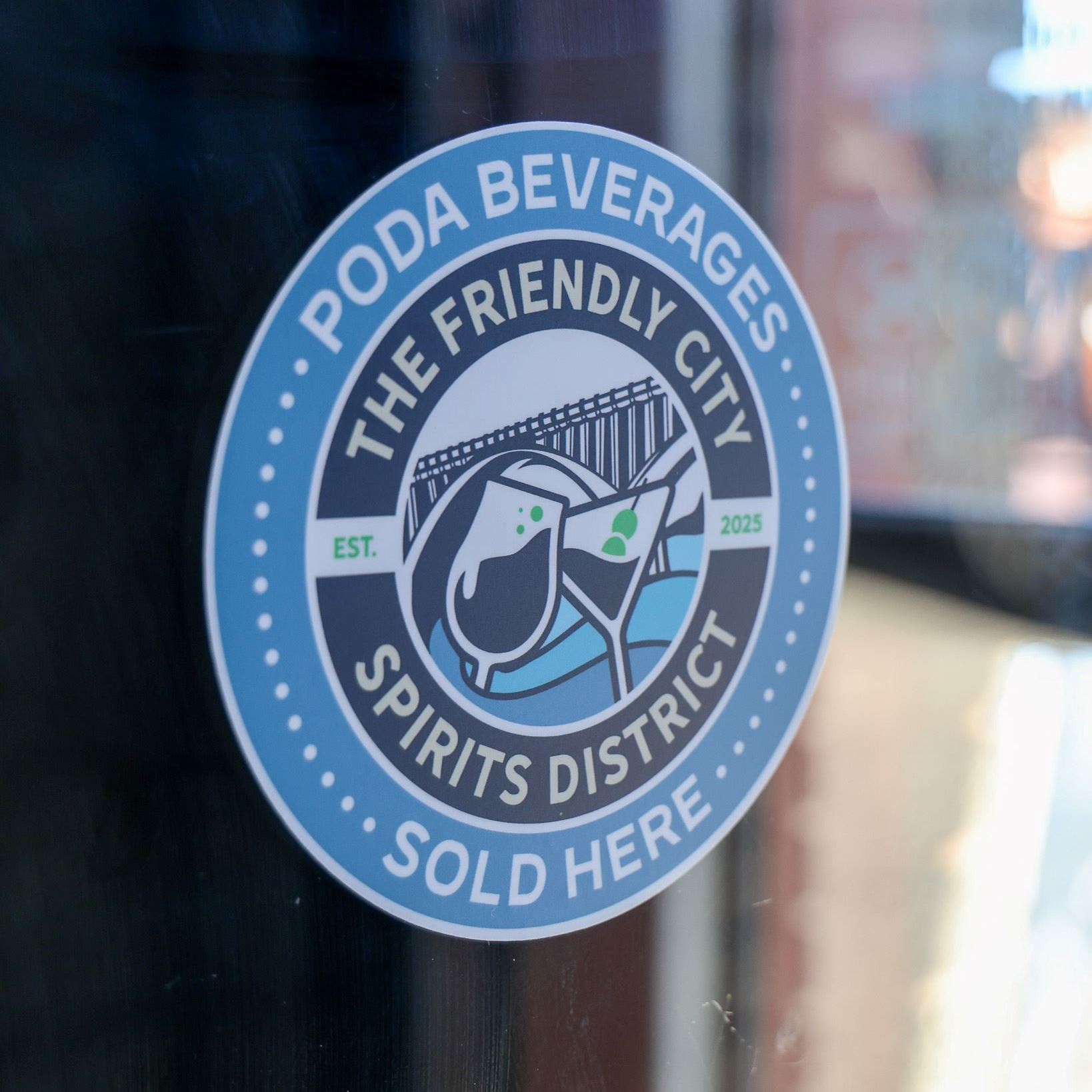 A sticker advertising the PODA district on a shop window.